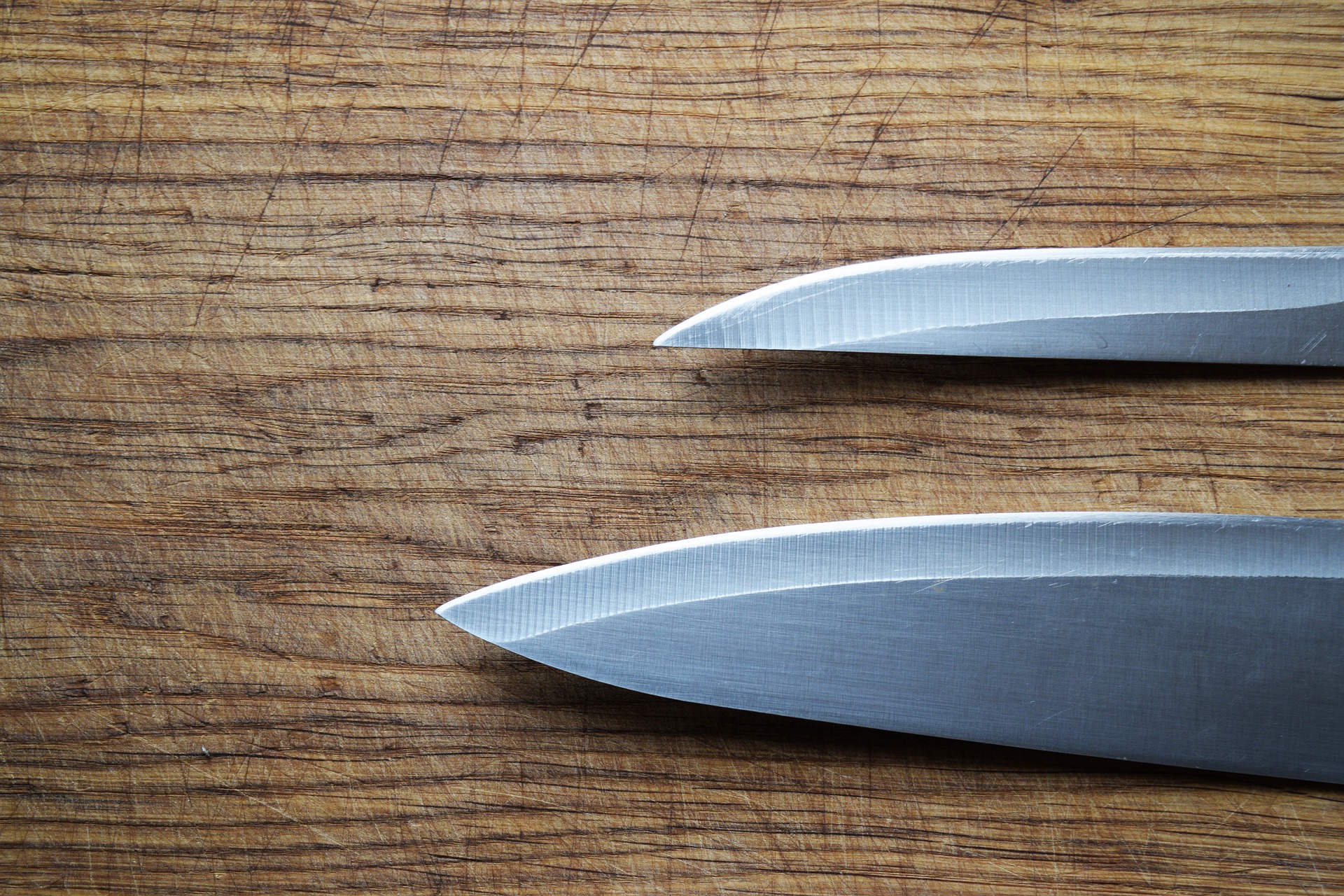 2 kitchen knives on a cutting board